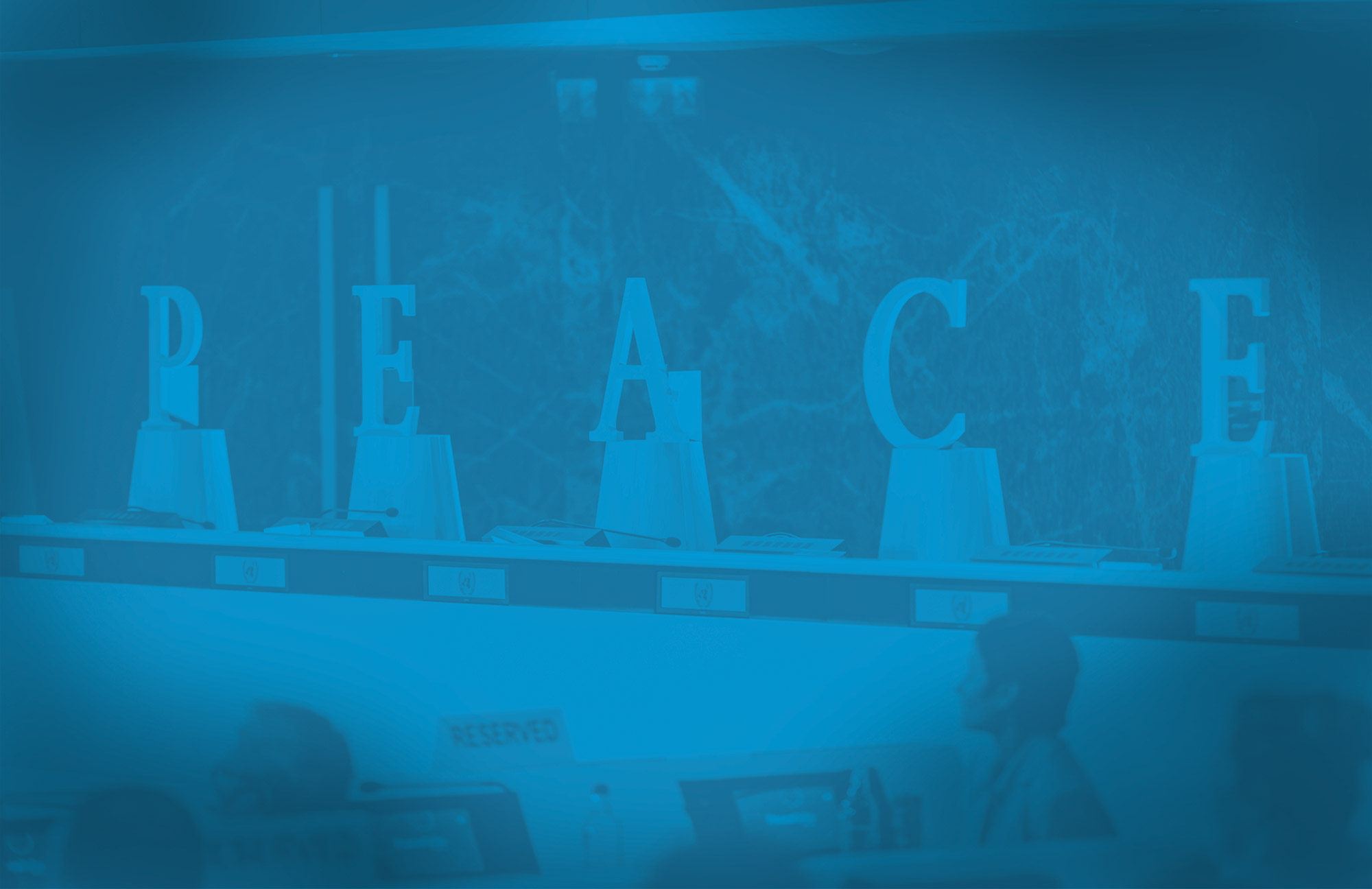 Wooden shaped letters are placed on a conference room podium to read the word 'Peace'. 