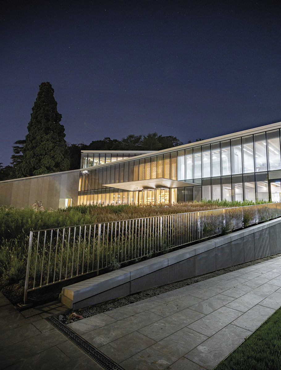 A new and modern building at night with lights on.